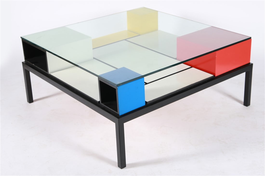 Piet Mondrian Style Coffee Table: Metal, wood, glass. Height: 18 3/8", Length: 40", Depth: 40". Piet Mondrian or De Stijl style coffee table with white, red, blue, and yellow blocks supporting a glass tabletop. Black metal base. Appea