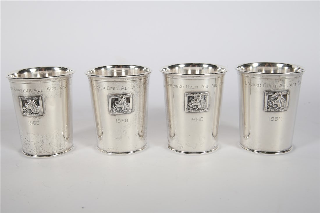 Four Sterling Silver Hunting Dog Trophy Cups: Webster. Sterling silver. Model 8555. Height: 3 3/4", Diameter: 3 1/8". Total weight: 15.620 ozt. Collection of four sterling silver trophy cups from the New Jersey Spaniel Field Trial Club. All troph