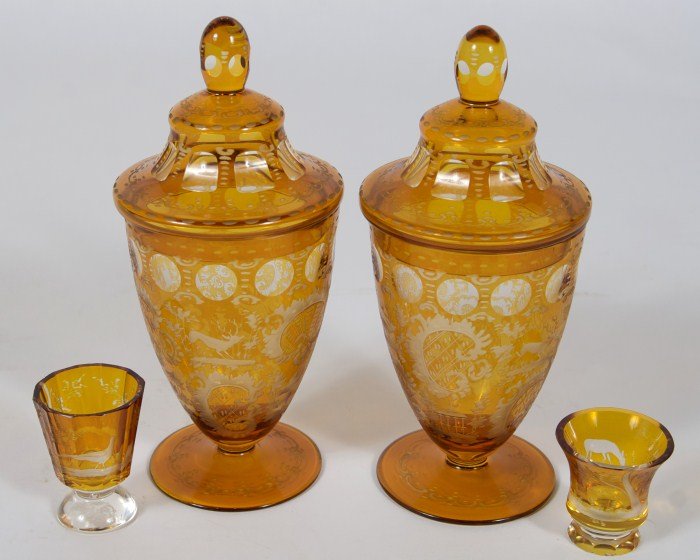 Two Bohemian Etched Amber Glass Urns, 20th C.: Two Bohemian etched amber glass urns. German, 20th century. Together with two shot glasses. Urns height 9".