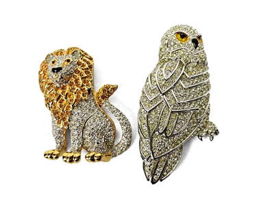 Swarovski, Owl and Lion Brooches: Swarovski, collection of two brooches. One gold-tone lion with white and amber colored crystals throughout, and a silver-tone owl with white crystals.