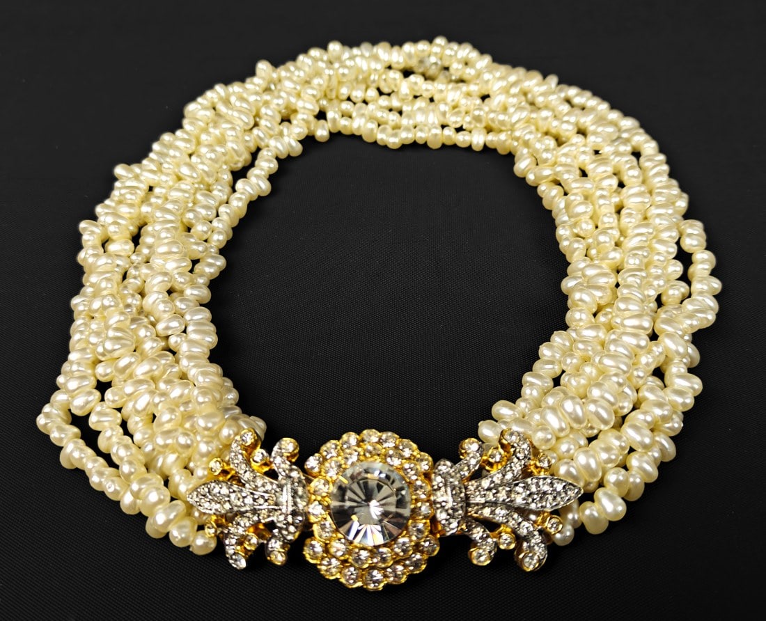Kenneth J. Lane, Multi-Strand Faux Pearl Necklace: Kenneth J. Lane, multi-strand faux pearl necklace. Features a large central gold and silver-tone centerpiece with variously sized white stones.
