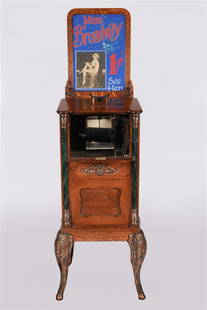 Cail-O-Scope "Miss Broadway" Peep Show Game: Caille Bros. Co. (American). "Cail-O-Scope" arcade machine. Oak, metal, 1904. Height: 72", Length: 22", Depth: 20". Cail-O-Scope "Miss Broadway" peep show 1c penny arcade game. Plates inside the machi