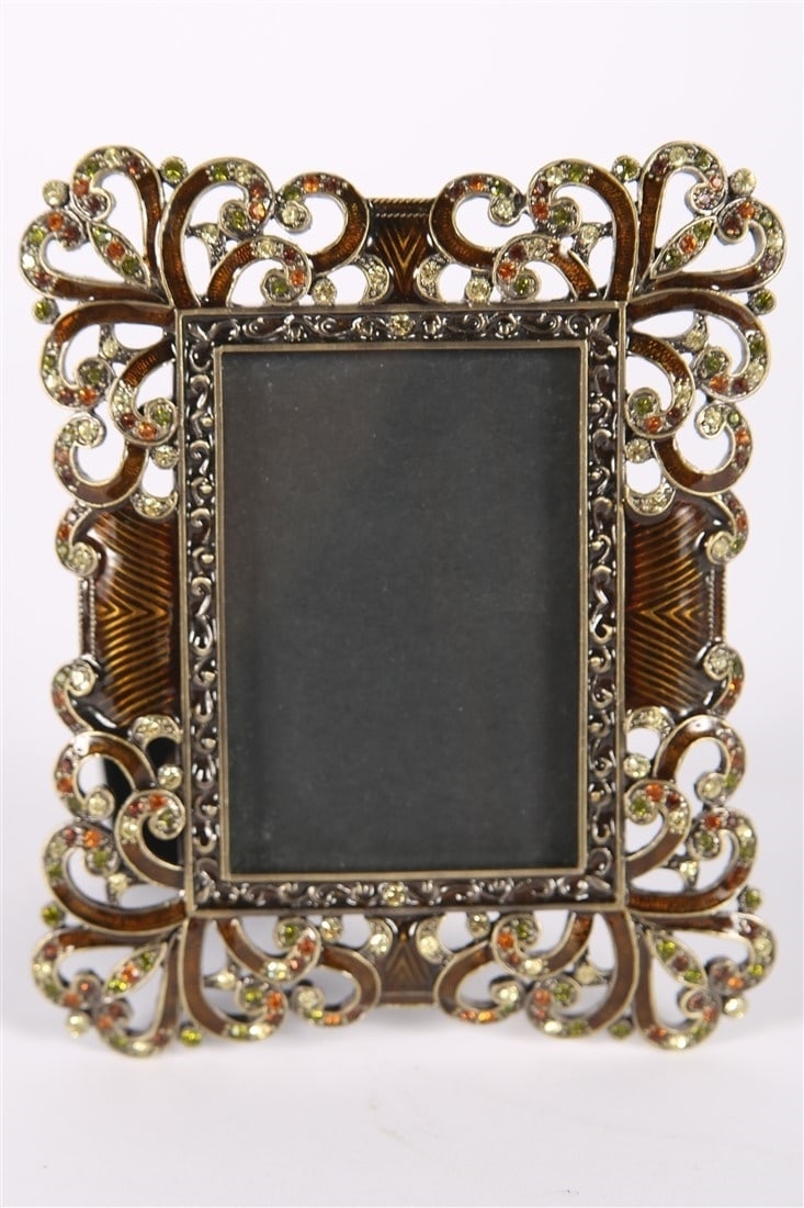 Style of Jay Strongwater, Enamel Flourish Frame: Enamel, rhinestones, metal. Sight: 3 1/8" x 2 1/8". Frame: 5 3/4" x 4 3/4". Jay Strongwater style enamel picture frame with flourish details and green and orange rhinestones. Unlabeled.