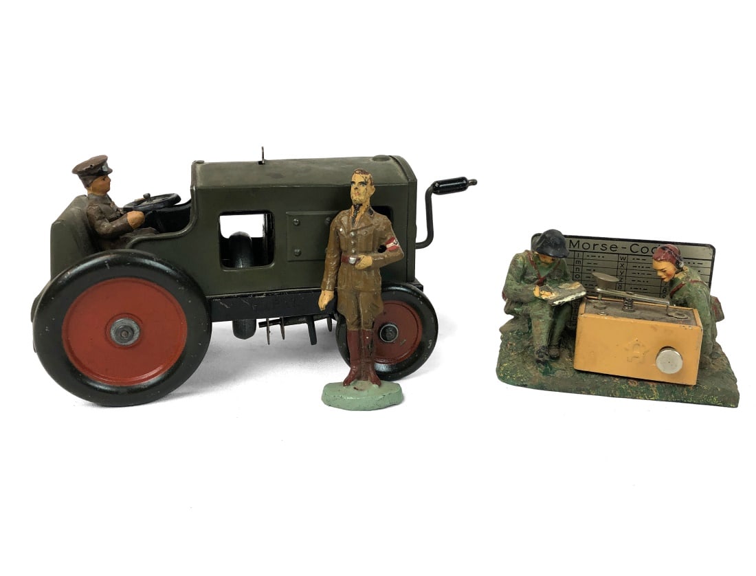 J.L. Hess Tractor & 2 Elastolin Figurines: Set includes two Elastolin / Hausser figures and a wind-up military tractor by J.L Hess. No original boxes included.