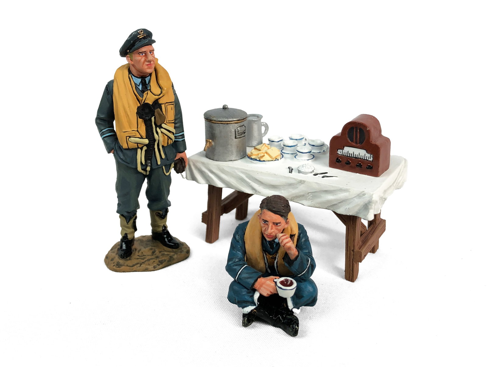 King & Country -Two RAF Figurines & Table: Lot includes:RAF012 - Flight Lieutenant Les Munro - RetiredRAF060 - Sitting & ThinkingRAF064 - Tea & Sandwich Table
