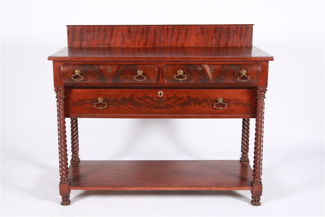 19th Century Mahogany Server: Carved mahogany, metal. Height: 40", Length: 48", Depth: 20 1/4". 19th century carved mahogany server or console table with three drawers and twisted column legs on claw feet.