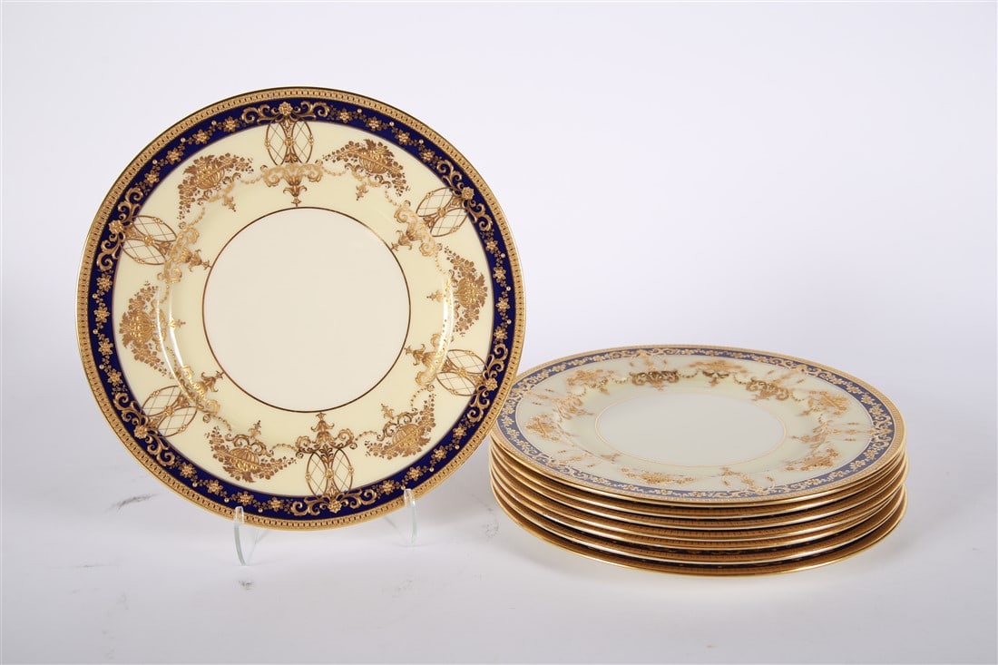 Lenox, Set of Eight Cream, Gold, Blue Plates: Lenox. Porcelain. Diameter: 10.5" Set of eight Lenox cream and white dinner plates with gilding and a blue painted border. Back is marked "Lenox Made Expressly for Ovington Bros. New York". Also marke