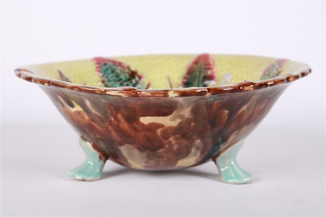 Majolica Footed Serving Dish: Glazed ceramic. Height: 4", Diameter: 10 5/8". Majolica footed serving dish. Fern and banana leaf motif to the interior.