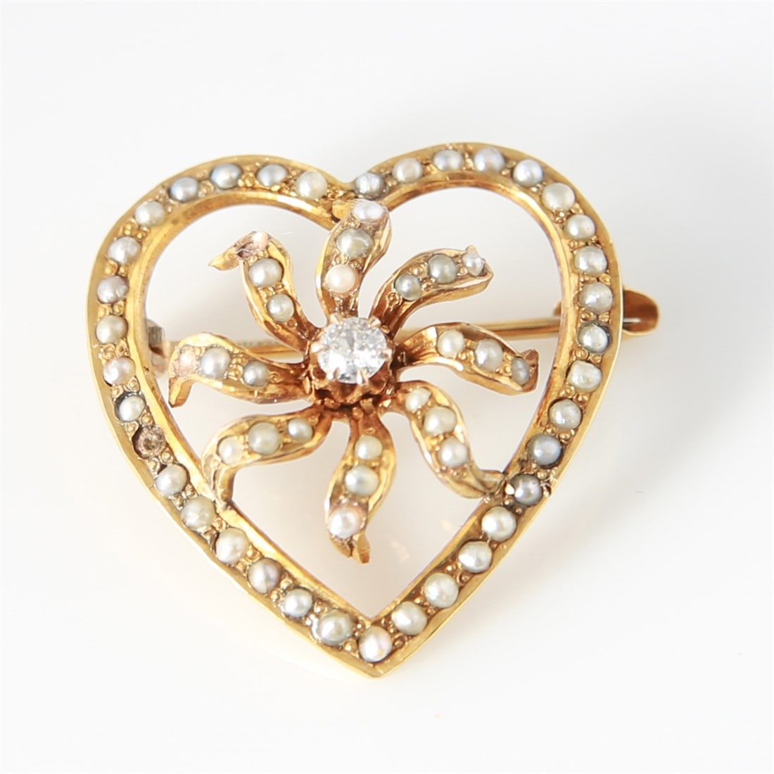10K Yellow Gold Heart Brooch: One open heart with center flower brooch made of 10 karat yellow gold. Brooch is set with (1) old European cut diamond and (59) seed pearls. Weighs a total of 2.7 grams. Diamond: (1) old European