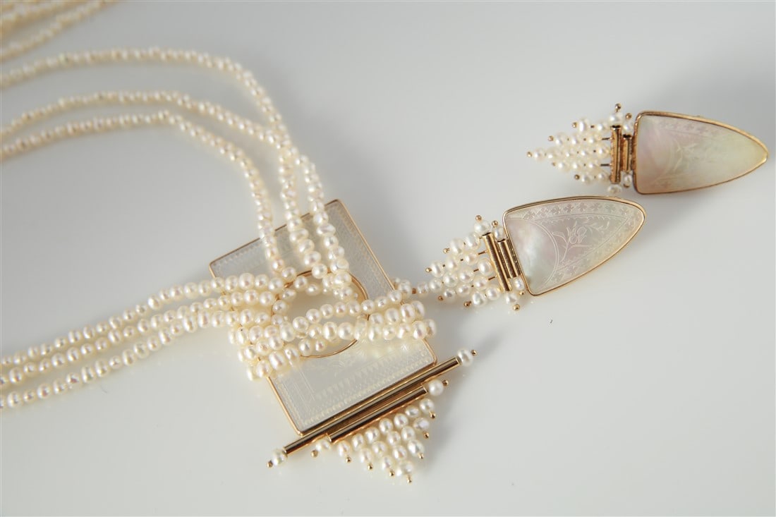 Seed Pearl Necklace And Earrings Set: One triple strand seed pearl necklace with a 14 karat yellow gold clasp. Necklace measures 24 inches long and includes one etched mother of pearl enhancer made of 14 karat yellow gold. Enhancer weighs