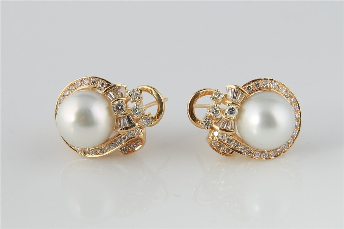 18k Yellow Gold Diamond Pearl Earrings: One pair of pearl and diamond earrings made of 18 karat yellow gold. Earrings are each set with (1) round South Sea pearl, surrounded by (6) tapered baguette cut and (30) round brilliant cut diamonds,