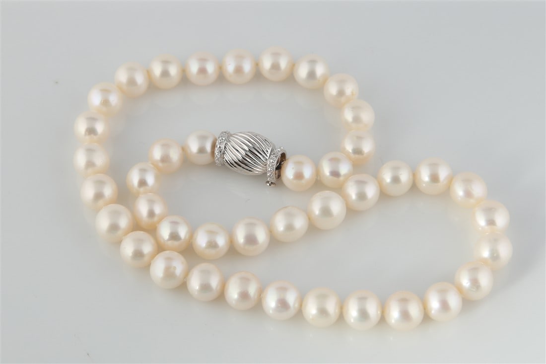 Pearl Necklace with 18k Diamond Clasp: One single strand pearl necklace with an 18 karat white gold diamond clasp. Necklace is made of (41) round Chinese pearls and clasp is set with (8) round brilliant cut diamonds. Necklace measures 16 i