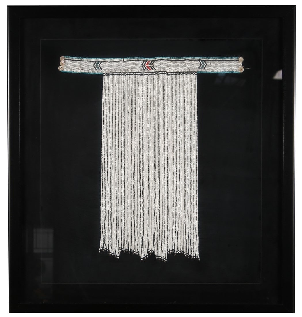 African Beadwork Loin Cloth: Beads, leather. Shadowbox: 27" x 25". Beaded loin cloth: 18" x 16". White beaded loin cloth with belt. White beads with blue, black, and red beads. Contained in a custom black-backed shadowbox.