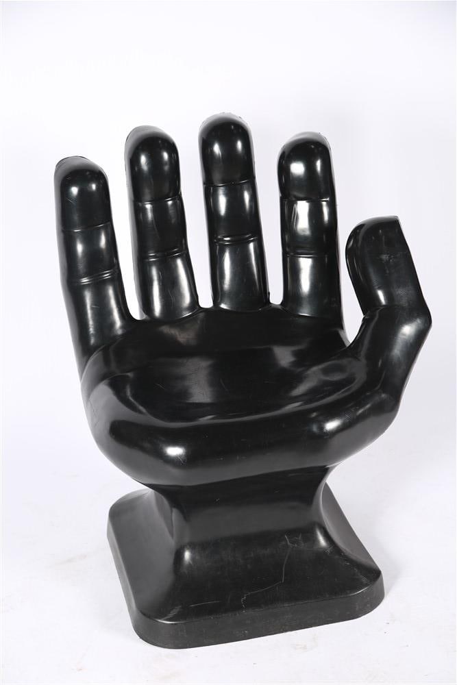 Black Plastic Hand Chair: Plastic. Height: 33 1/2", Length: 26", Depth: 21". Black plastic molded chair in the shape of a hand.