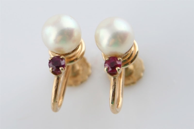 Pair of 14k Yellow Gold, Pearl and Ruby Earrings: Earrings have screw clip backs and weigh 3.6 grams. Two (2) cultured pearls measure 6.7mm to 6.8mm (approx.), and the two (2) round cut rubies measure 2.8mm (approx.).
