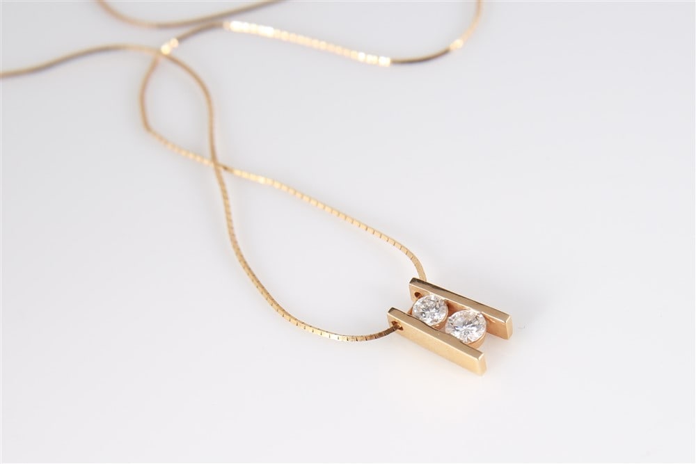 14k Yellow Gold Diamond Pendant Necklace: 14k yellow gold, diamond. Chain length: 20", Pendant length: 1/2". Weight including stones: 3.5 grams. 14k yellow gold chain with a yellow gold and diamond pendant. Pendant with two round cut diamonds