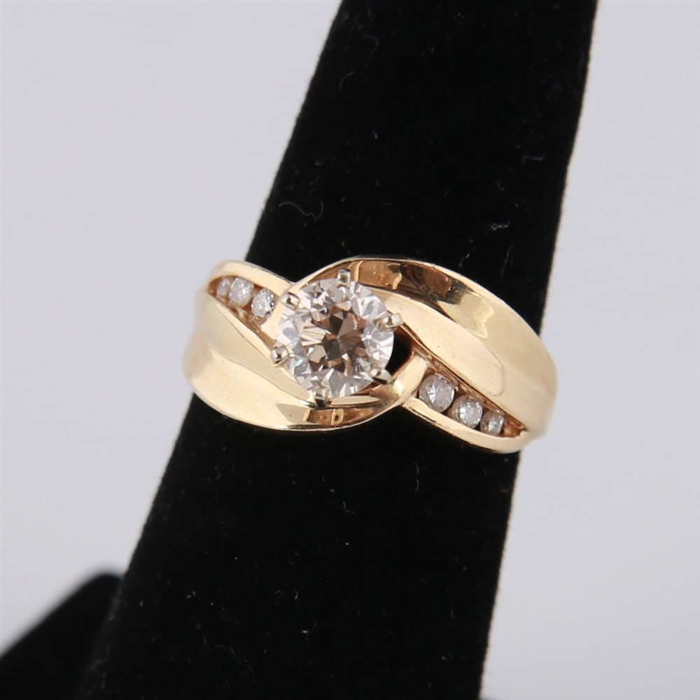 14k Yellow Gold and Diamond Twist Ring: 14k yellow gold ladies twist ring with 3/4 ct central diamond flanked by three smaller diamonds to each side. Size: 6. Total weight including diamonds: 6.4g.