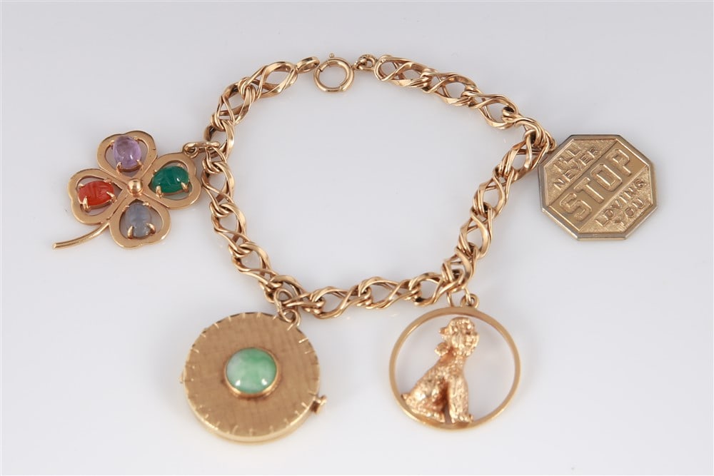 14k Yellow Gold Bracelet with Four Charms: Yellow gold, gemstone. Length: 7 1/4". Weight: 38.7 grams. 14k yellow gold fancy link bracelet with a spring ring clasp and four charms. Charms include a 14k yellow gold four leaf clover with four ova