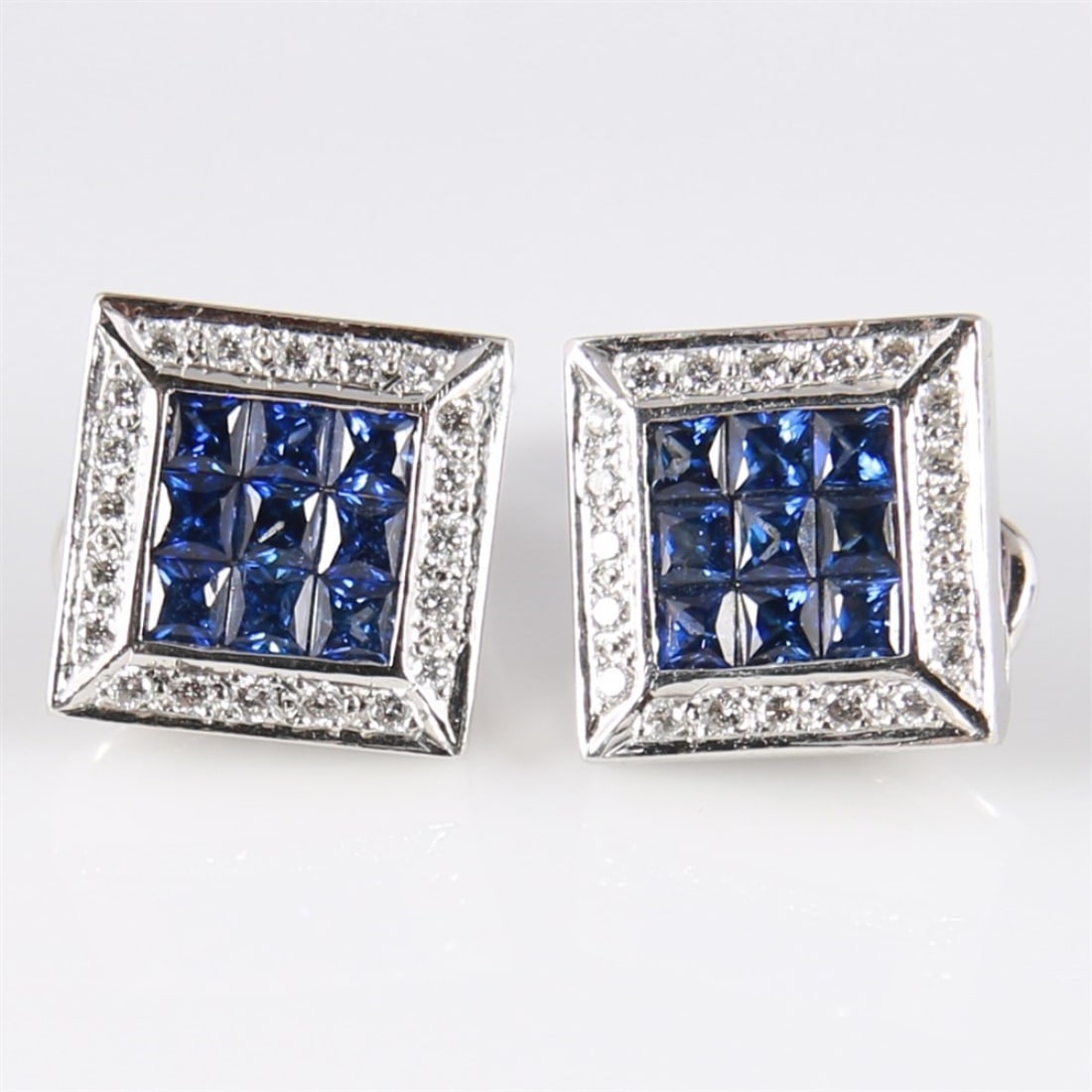 18k White Gold Diamond Sapphire Earrings: 18k white gold, sapphire, diamond. Height: 1/2", Length: 1/2". Weight including stones: 8.6 grams. 18k white gold clip-on or pierced convertible earrings set with sapphires and diamonds. Each earring 