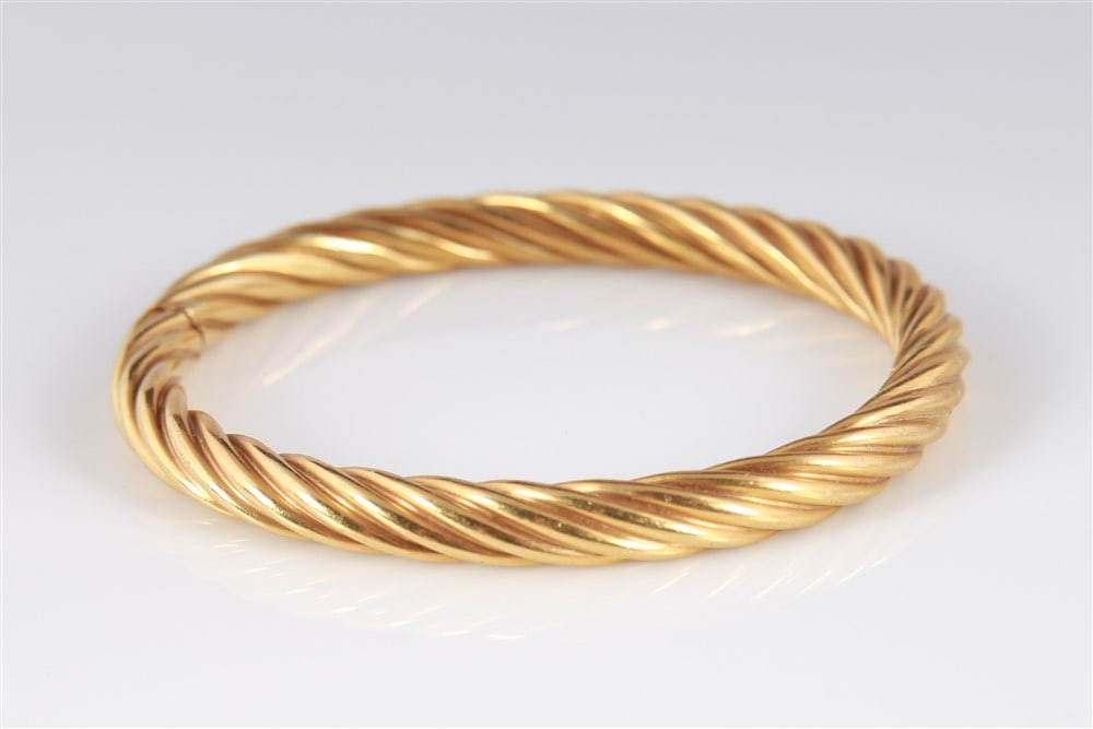 Tiffany and Co., 18k Yellow Gold Twist Bracelet: Tiffany and Co., 18k yellow gold twisted design bracelet. Hinge and box style clasp. Width: 6.75mm. Weight: 22.1g.