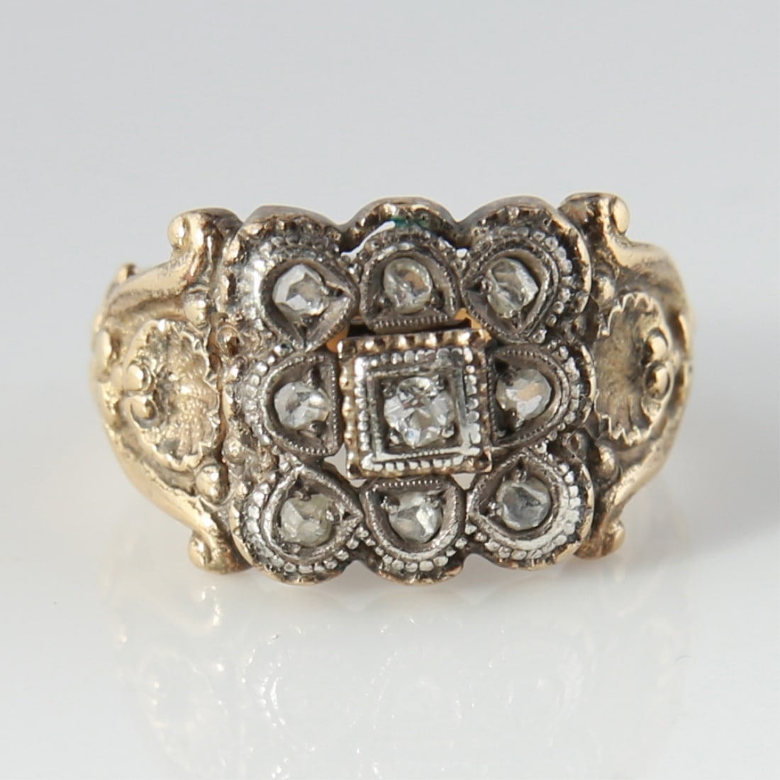 18k Yellow Gold and Diamond Ring: One antique style ring made of 18 karat yellow gold with a silver top. Ring is set with (9) rose cut diamonds. Total weight: 9.3 grams. Ring measures a size 8. Diamonds: (9) rose cut, .25ct est. total