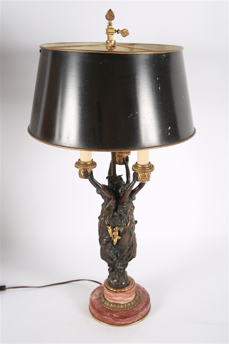 French Empire Style Figural Bronze Table Lamp: Bronze, marble, brass, metal. Height: 29", Diameter: 6". French Empire style table lamp featuring three bronze goddess figures on a pink marble base. Features three candelabra style sockets, a tole me