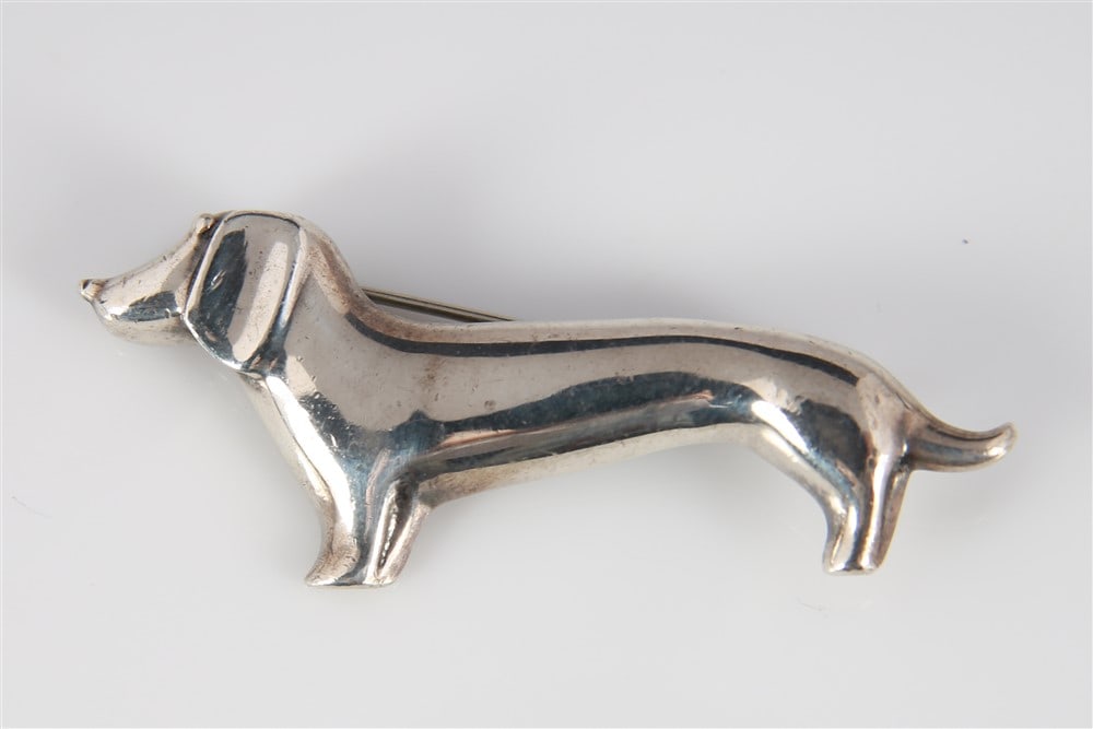 Mexican Sterling Dachshund Brooch: Sterling Silver: Height: 3/4", Length: 2 1/8". Weight: .31 ozt. Sterling silver figural dog brooch. Marked at back and weighs a total of .31 ozt.