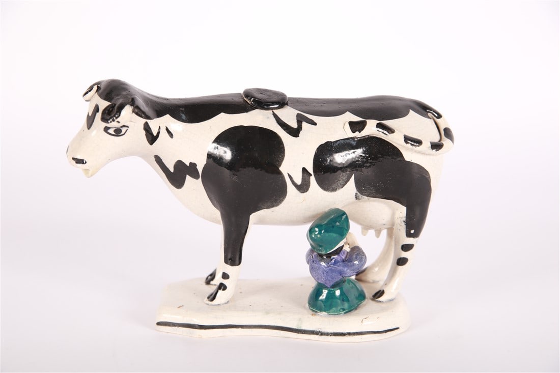 Staffordshire, Cow Creamer with Milk Maid: Staffordshire (English, established 18th century). Earthenware. Height: 5", Length: 5 1/2", Depth: 3". Staffordshire figurine of a milk maid milking a black and white cow.