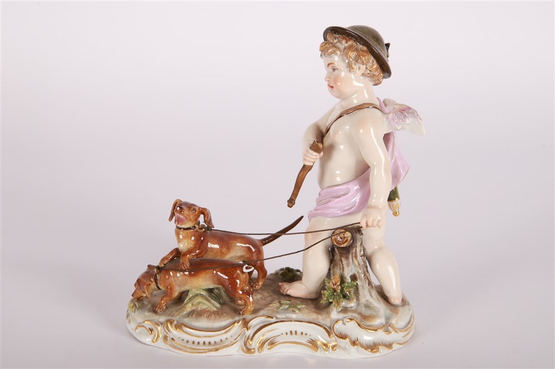 Meissen, "Cupid With Hunting Dogs" Porcelain: Meissen (German, established 1710). "Cupid With Hunting Dogs". Porcelain. Modeled by August Ringler. Model Q 182. Height: 6 1/2", Length: 5", Depth: 3". Modeled by August Ringler for Meissan. A