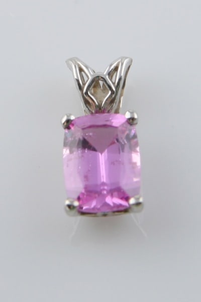 14k White Gold and Pink Sapphire Pendant: Pendant is set with one (1) emerald cut pink sapphire, four-prong set. Total weight: .7 grams.