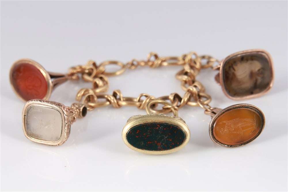 14k/10k Yellow Gold Bracelet With Five Fob Charms: Yellow gold, stones. Length: 7 1/2". Weight: 79.2 grams. 14K yellow gold fancy link bracelet with a spring ring clasp and five gold fob charms. Fob gemstones include agate, onyx, bloodstone, and sardo