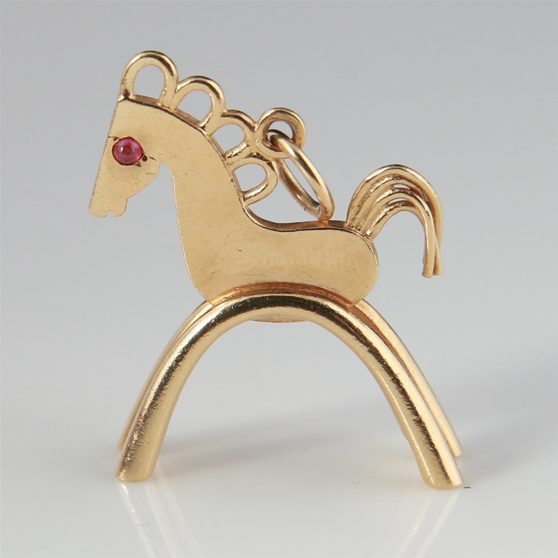 14k Yellow Gold Horse Charm with Ruby Eye: 14k yellow gold, ruby. Height: 1 1/8", Length: 1". Weight: 6.9g. 14k yellow gold horse charm with single red ruby eye. Marked "14K" to the leg.