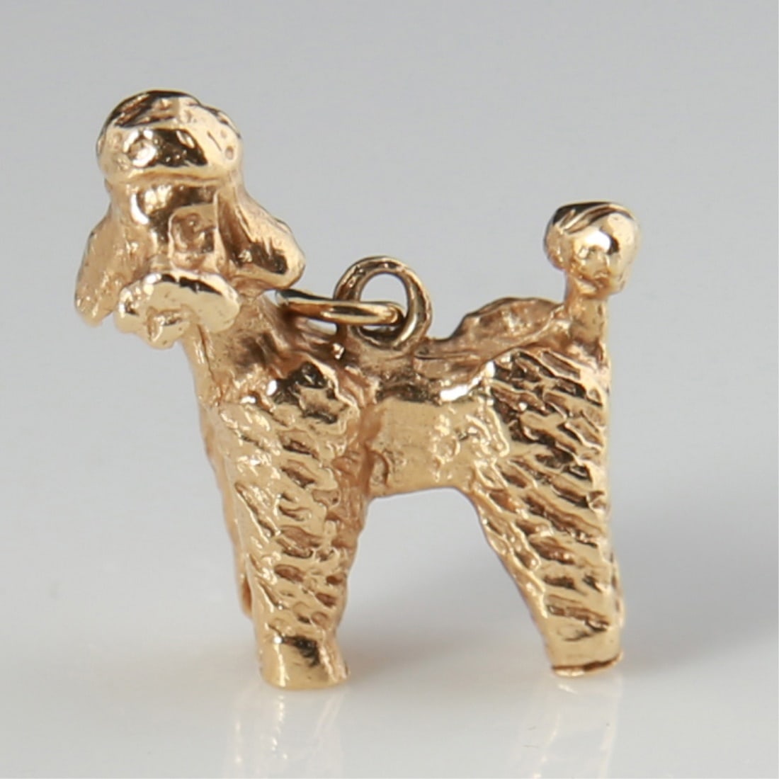 14k Yellow Gold Poodle Charm: 14k yellow gold. 3/4" x 5/8". Weight: 4.5g. 14k yellow gold poodle charm. Appears unmarked; tests 14k.