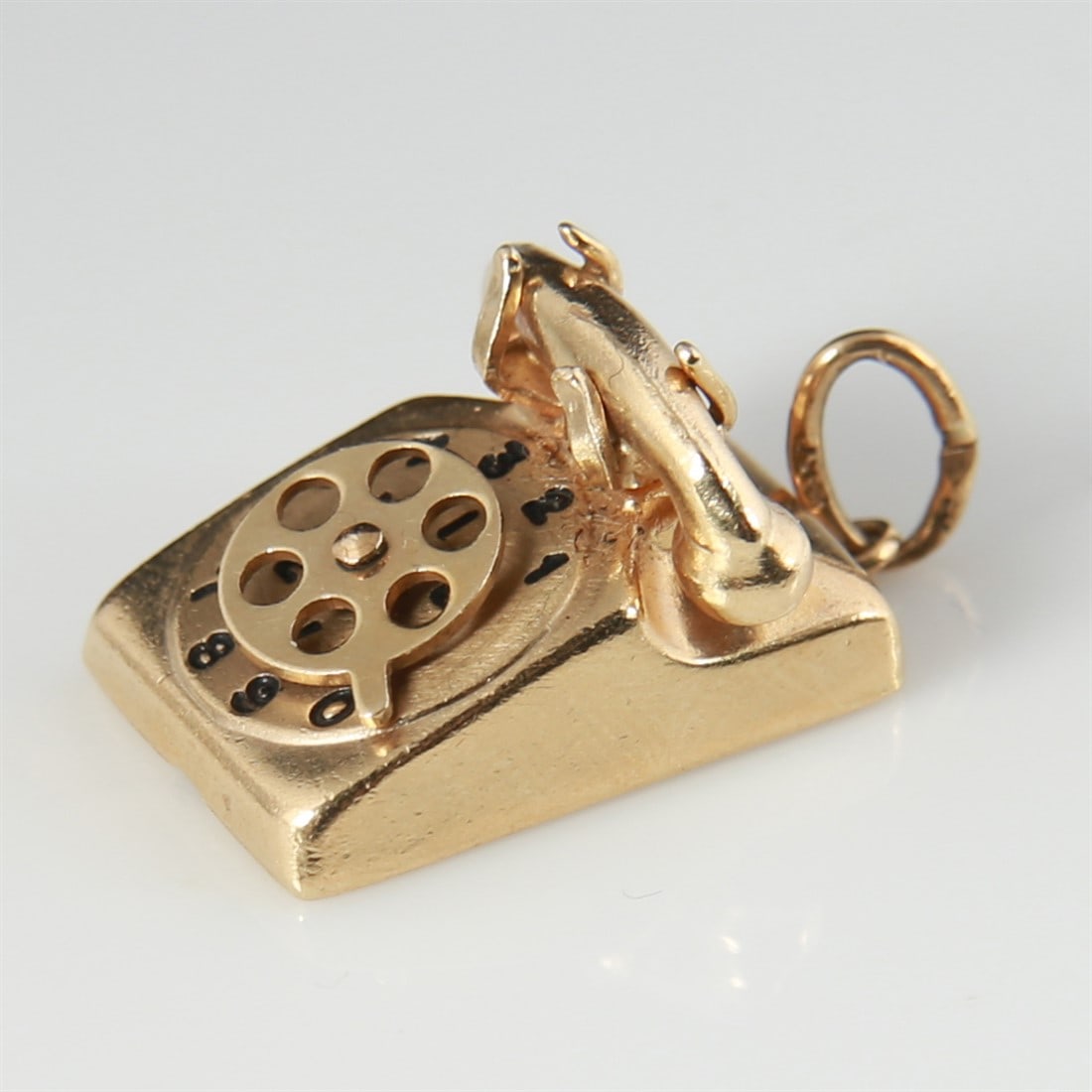 14k Yellow Gold Rotary Phone Charm: 14k yellow gold. 3/4" x 1/2" x 1/2". Weight: 4.3g. 14k yellow gold rotary phone charm. Dial on phone rotates. Marked 14K.