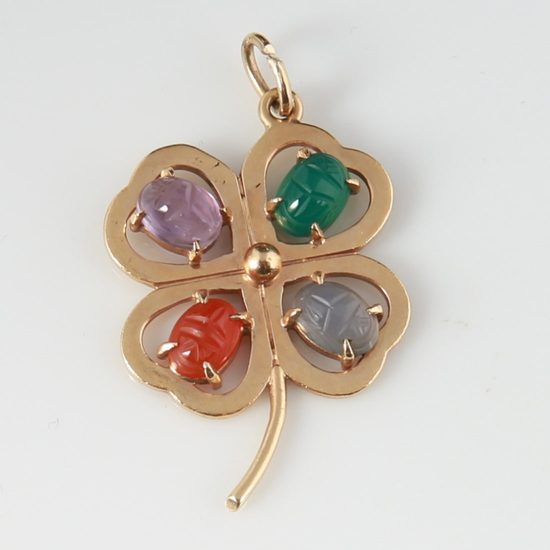 14k Yellow Gold Semi-Precious Clover Charm: 14k yellow gold, semi-precious stones. 1 1/4" x 1". Weight (including stones): 5.5g. 14k yellow gold four leaf clover charm containing four oval scarabs carved from amethyst, carnelian, green onyx, an