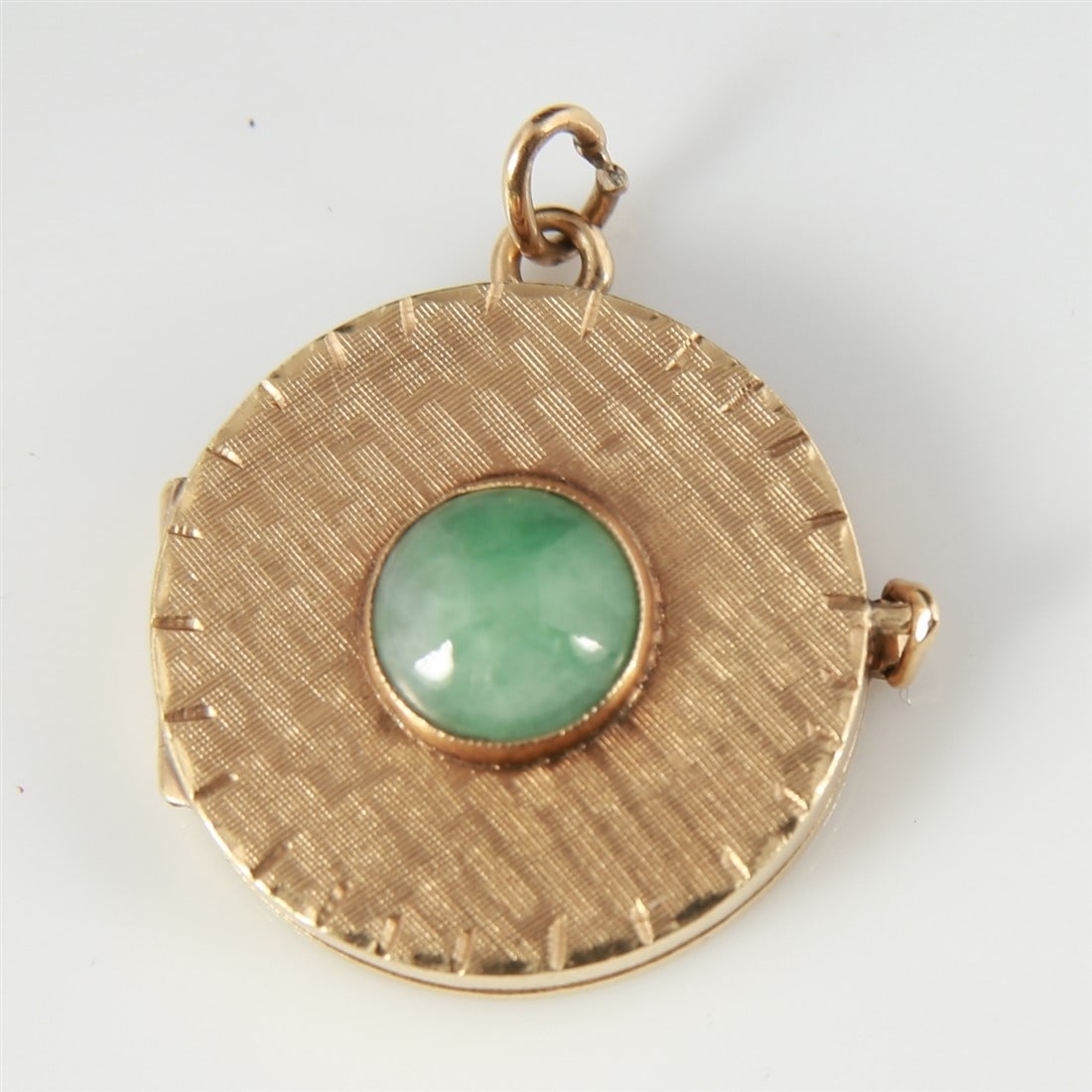 14k Yellow Gold Triple Locket with Jade: 14k yellow gold, jade. Diameter: 1". Weight (including stone): 10.4g. 14k yellow gold triple panel locket with round jade cabochon. Marked 14K inside first panel.