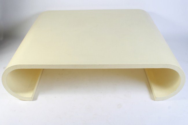 Karl Springer Waterfall Coffee Table: Mid-century cream lacquered waterfall scroll form coffee table. American, circa 1970. Designed by Karl Springer. With rectangular lacquer over linen top and curled legs. Height 15 1/2", width 60", dep