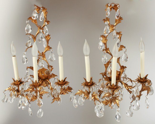 Pair Louis XV Style Gilt Iron Wall Sconces: Pair Louis XV Style gilt iron and crystal wall sconces. French, 19th century. Gilt iron foliate back plate issuing three candle arms with cut crystal drops. Height 21 1/2", width 13 1/2".
