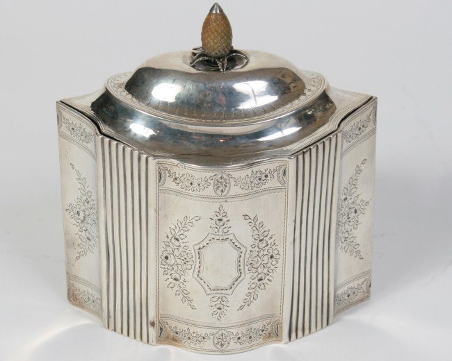 George III Silver Tea Caddy, Early 19th C.: Peter, Ann & William Bateman George III silver tea caddy. English, early 19th century. Pointed ovular form with chased foliate and reeded decoration enclosing a cartouche on each side. Domed hinged li
