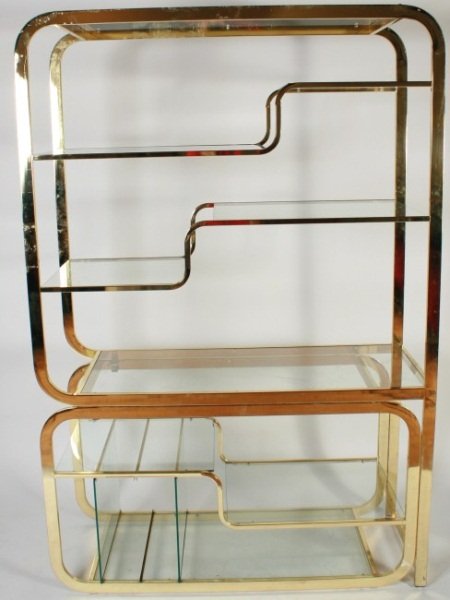 Milo Baughman for DIA Brass Etagere: Milo Baughman for Design Institute America brass plated etagere. American, circa 1970. Brass frame having three long glass shelves and six staggered glass shelves. Bottom shelf with glass dividers. DI