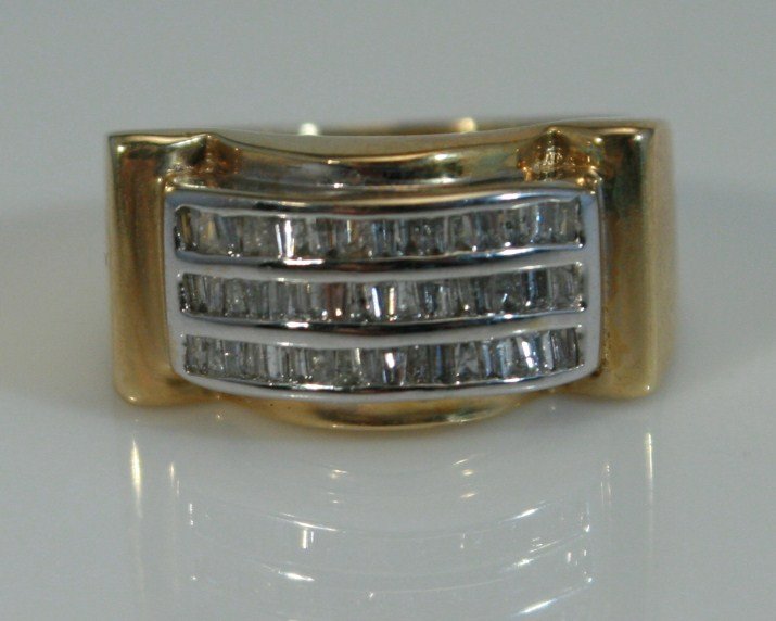 14K Gold Baguette Diamond Ring: 14 karat yellow gold baguette diamond ring. 20th century. 14 karat yellow gold band with a 14 karat white gold inset, set with 48 baguette cut diamonds, 0.75 ct. total weight. Ring size 8 1/2. 14 kara