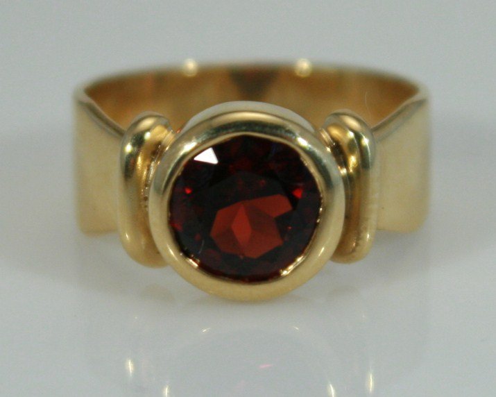 18K Gold Ring with Garnet: 18 karat yellow gold ring with garnet. 20th century. 18 karat band set with one garnet. Ring size 5 1/2. 18 karat gold weight 5.9 grams. Condition: Appears fine.