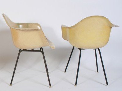 Pair Charles & Ray Eames Shell Chairs: Pair Charles & Ray Eames molded fiberglass shell chairs. American, 20th century. Made by Herman Miller. Molded white and pale yellow fiberglass shell chairs with tubular metal legs ending in nylon gli