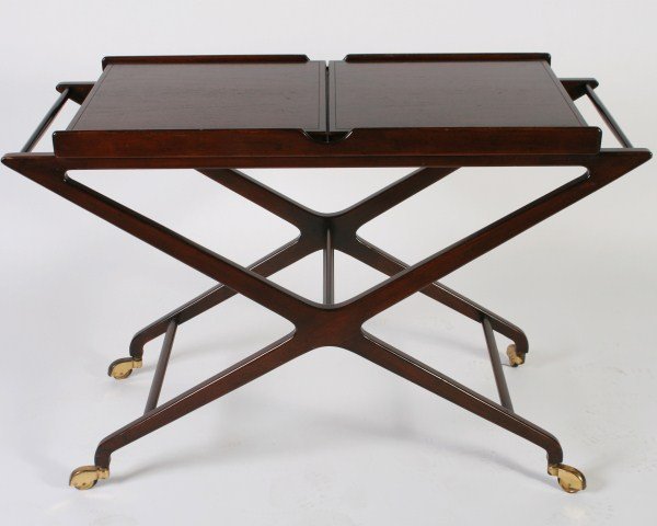 Mid-Century Mahogany Serving Cart, American: Mid-century mahogany serving cart. American, mid 20th century. Mahogany server with fold-out extendable top with white laminate interior over x-form legs on brass casters. Unmarked. Height 28 3/4", wi