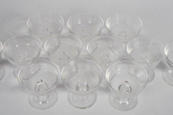 12 Steuben Teardrop Champagnes, by George Thompson: Twelve Steuben glass teardrop champagnes. American, circa 1958. Squared bowl over baluster form stem having trapped teardrop at center. Designed by George Thompson. Signed underfoot. Height 4 1/8".