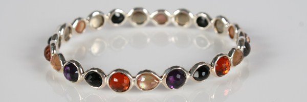 Ippolita Wonderland Bangle: Ippolita Wonderland bangle with semiprecious stones. 20th century. Hammered sterling silver bangle set with mother-of-pearl, onyx, purple quartz, and orange quartz doublets backed with mother-of-pearl