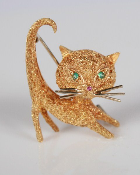18K Yellow and White Gold Cat Brooch: 18 karat yellow and white gold cat brooch. 20th century. 18 karat yellow gold cat brooch having eyes set with two round emeralds and a nose set with one round ruby and white gold wire whiskers. Total