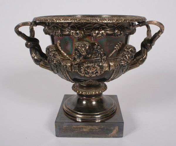 Silverplate Urn After the Warwick Vase: Silverplate urn after the Warwick vase. Probably 19th century. Silverplate urn having reeded intertwined handles and Bacchic decoration raised on a square base. With manufacturer's mark to base. Heigh