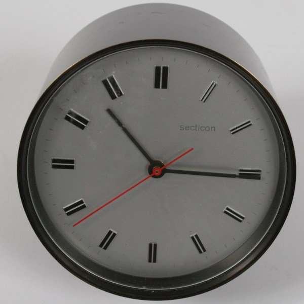 Angelo Mangiarotti Secticon Metal Desk Clock: Secticon metal desk clock designed by Angelo Mangiarotti. 20th century. Clock dial marked "Secticon" and "Swiss Made Pat. Portescap Lic. Ato." along the lower edge. Height 4 1/2", length 5".