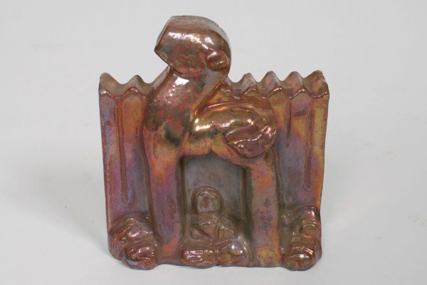 Pewabic Iridescent Pottery Figure: Pewabic iridescent pottery figure. American, 20th century. Iridescent pottery figure depicting an animal in front of a picket fence. With impressed "Pewabic Detroit" mark to base. Height 4 3/4", width